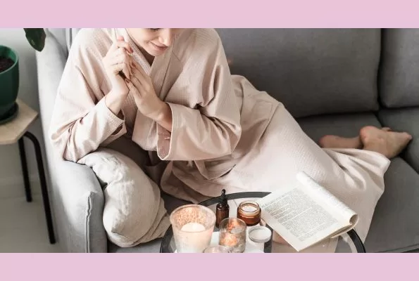 Simple Joy - woman sitting in robe at home reading a book with candles. Very cozy