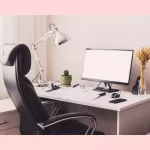 Home Office set-up for remote work with ergonomic chair, monitor, desk and lamp