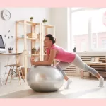 A woman balancing on a stability ball as she works out from home