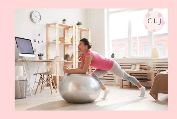 A woman balancing on a stability ball as she works out from home