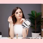 Girl applying makeup when working from home.