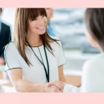 Two women at a networking even shaking hands while gaining professional development