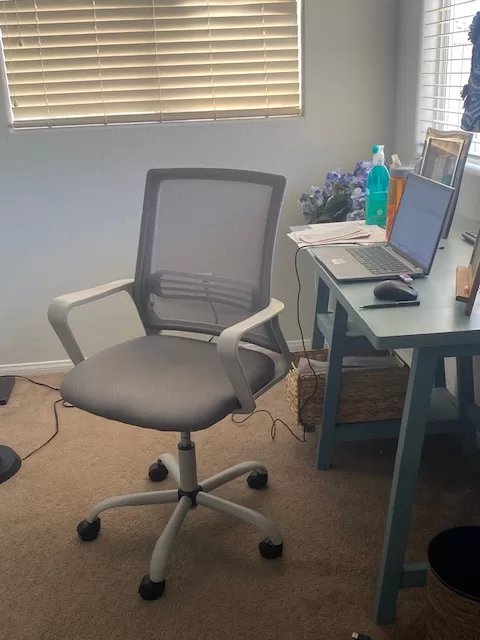 Stylish grey office chair for working from home shown at a blue desk.  
