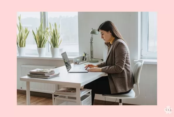 A woman working at a desk in her office on a laptop